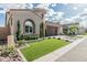 Single Gathering home featuring a two-car garage, manicured lawn, brick paved driveway, and distintive turret entry at 5653 E Sayan St, Mesa, AZ 85215