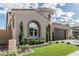 Exterior view of the home featuring a manicured lawn, trees, and distinctive turret entry at 5653 E Sayan St, Mesa, AZ 85215