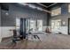 A modern gym with dark grey walls, white accents, lots of windows, and exercise equipment at 5653 E Sayan St, Mesa, AZ 85215