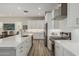 Gourmet kitchen featuring white cabinets, quartz countertops, stainless steel appliances, and gas range at 5653 E Sayan St, Mesa, AZ 85215