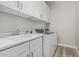 Convenient laundry room featuring a sink, white cabinets, and modern washer and dryer at 5653 E Sayan St, Mesa, AZ 85215