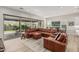 Spacious living room features a large brown sectional, wood floors, and a view of the backyard at 5653 E Sayan St, Mesa, AZ 85215
