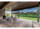 Relaxing covered patio with stylish pavers, outdoor seating, and lush green lawn at 5653 E Sayan St, Mesa, AZ 85215