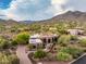 Expansive aerial view of a luxury home with lush landscaping and mountain views at 5690 E Canyon Creek Cir, Carefree, AZ 85377