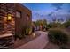 Charming home with desert landscaping, an inviting brick walkway, and exterior lighting at 5690 E Canyon Creek Cir, Carefree, AZ 85377