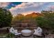 Inviting fire pit area with cushioned seating and stunning mountain views, perfect for outdoor relaxation at 5690 E Canyon Creek Cir, Carefree, AZ 85377