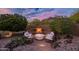 Inviting fire pit area with cushioned seating, lighting and mountain views, perfect for relaxing evenings at 5690 E Canyon Creek Cir, Carefree, AZ 85377