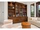 Cozy living room featuring custom built-ins, comfortable seating, and a view of the outdoors at 5690 E Canyon Creek Cir, Carefree, AZ 85377