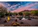 Backyard oasis features a swimming pool, fire pit, and lush desert landscaping with mountain views at 5690 E Canyon Creek Cir, Carefree, AZ 85377