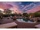 Inviting outdoor pool area with a fire pit, lush desert landscaping, and picturesque mountain views at 5690 E Canyon Creek Cir, Carefree, AZ 85377
