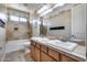 Well-lit bathroom featuring dual sinks, vanity, and tiled shower, providing a comfortable and stylish space at 5826 W Plum Rd, Phoenix, AZ 85083