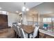 Open-concept dining room featuring a large wood table with white chairs and hardwood floors at 5826 W Plum Rd, Phoenix, AZ 85083