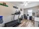 This exercise room has a treadmill, desk, chair, shelves, and window for a bright and airy workout at 5826 W Plum Rd, Phoenix, AZ 85083