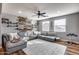 Spacious living room with wood floors, large sectional sofa, wall shelving and drum set at 5826 W Plum Rd, Phoenix, AZ 85083