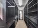Large walk-in closet featuring extensive dark wood shelving, drawers, and a central mirror for organization at 5826 W Plum Rd, Phoenix, AZ 85083