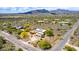 Aerial view of neighborhood with a home that has solar panels, landscaping, and a pool in desert landscape at 5978 E Chuckwalla Trl, Cave Creek, AZ 85331