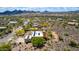 An aerial view showcases a desert home with solar panels and views of mountains in the distance at 5978 E Chuckwalla Trl, Cave Creek, AZ 85331