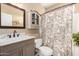 Cozy bathroom featuring a vanity with marble countertop and a shower with floral curtain at 5978 E Chuckwalla Trl, Cave Creek, AZ 85331