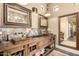 Rustic bathroom featuring a wood vanity with dual sinks and decorative mirrors at 5978 E Chuckwalla Trl, Cave Creek, AZ 85331