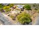 Aerial view of a desert home that features a two car garage, vibrant desert landscaping, and a solar panel roof at 5978 E Chuckwalla Trl, Cave Creek, AZ 85331