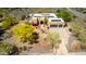 Aerial view of an inviting home with a two-car garage, swimming pool, solar panels, and desert landscaping at 5978 E Chuckwalla Trl, Cave Creek, AZ 85331