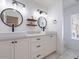 Modern bathroom with double sinks, black fixtures, and stylish round mirrors at 6130 N 12Th Way, Phoenix, AZ 85014