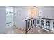 Hallway with decorative railing, updated light fixture and bathroom with double sinks in the background at 6130 N 12Th Way, Phoenix, AZ 85014