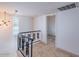 Hallway with decorative railing, updated light fixture and doorway to another room at 6130 N 12Th Way, Phoenix, AZ 85014