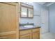 A bathroom with a wood vanity, mirror, and tile flooring, creating a simple and functional space at 6939 W Cambridge Ave, Phoenix, AZ 85035