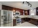 Gourmet kitchen featuring stainless steel appliances, granite counters and custom dark wood cabinetry at 6939 W Cambridge Ave, Phoenix, AZ 85035