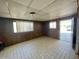 Simple living room with linoleum floors, wood paneled walls and natural light from exterior windows at 7214 S 42Nd St, Phoenix, AZ 85042