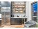 Convenient bar area with a wine cooler, stainless steel refrigerator, and stylish shelving for beverages at 7438 E San Jacinto Dr, Scottsdale, AZ 85258