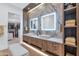 Elegant bathroom featuring double sinks, marble accents, vanity lighting, and a walk-in closet at 7438 E San Jacinto Dr, Scottsdale, AZ 85258
