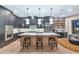 Contemporary kitchen with a large center island, pendant lighting, and stainless steel appliances at 7438 E San Jacinto Dr, Scottsdale, AZ 85258