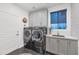 Modern laundry room equipped with gray cabinetry, stainless steel appliances, and a convenient sink area at 7438 E San Jacinto Dr, Scottsdale, AZ 85258