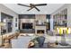 Modern living room with a stone fireplace, large sectional sofa, and stylish decor at 7438 E San Jacinto Dr, Scottsdale, AZ 85258