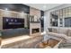 Cozy living room featuring a fireplace, plush sofa, modern entertainment center and decorative mirror at 7438 E San Jacinto Dr, Scottsdale, AZ 85258