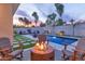 Relaxing outdoor space with a pool, fire pit, comfortable seating, and lush landscaping for ultimate enjoyment at 7438 E San Jacinto Dr, Scottsdale, AZ 85258