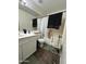 This bathroom has a bathtub with shower, single sink vanity, and wood-look flooring at 7664 W Vermont Ave, Glendale, AZ 85303