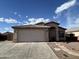 Front exterior view features a two-car garage, desert landscaping, and stucco construction at 7664 W Vermont Ave, Glendale, AZ 85303