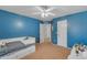 A bedroom with blue walls features a ceiling fan and a view to the hallway at 780 S Lagoon Dr, Gilbert, AZ 85233