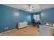 Bright bedroom with blue walls featuring a ceiling fan, window, dresser, and a playful atmosphere at 780 S Lagoon Dr, Gilbert, AZ 85233