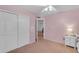 Light pink bedroom with ceiling fan offers neutral carpeting, closet and view to living area at 780 S Lagoon Dr, Gilbert, AZ 85233