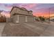 Two-story home with a three-car garage and desert landscaping during sunset at 780 S Lagoon Dr, Gilbert, AZ 85233