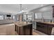 Open kitchen featuring an island with granite countertops and dark brown cabinetry overlooking the living area at 780 S Lagoon Dr, Gilbert, AZ 85233