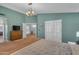 Bright and airy bedroom with a modern chandelier, double doors, and a large comfortable bed at 780 S Lagoon Dr, Gilbert, AZ 85233