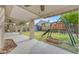 Large covered patio with a ceiling fan, leading to a spacious backyard with a playground at 780 S Lagoon Dr, Gilbert, AZ 85233