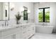 Modern bathroom with double sinks, soaking tub, and large window at 7902 E Via Linda --, Scottsdale, AZ 85258