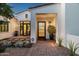 Inviting home entrance with a modern black door, elegant lighting, and a brick pathway at 7902 E Via Linda --, Scottsdale, AZ 85258