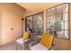 Cozy balcony with sliding glass doors leading inside, complemented by comfortable seating and natural light at 8700 E Mountain View Rd # 2011, Scottsdale, AZ 85258
